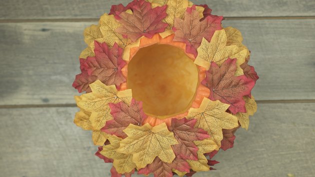 Decorating DIY Pumpkin Keg with fabric leaves