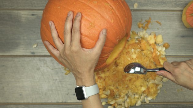 Scoop out pumpkin to make DIY Pumpkin Keg
