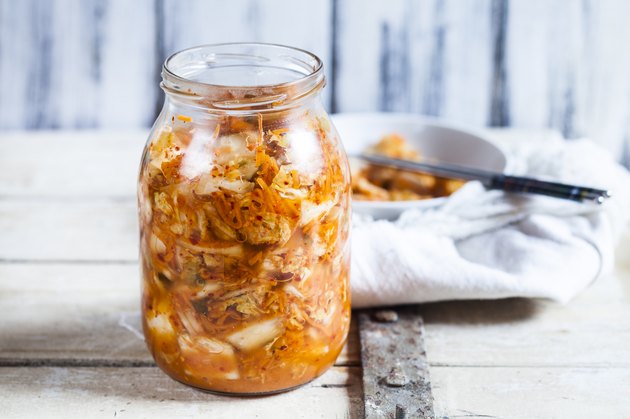Glass of homemade Korean Kimchi with chinese cabbage, scallions and carrots