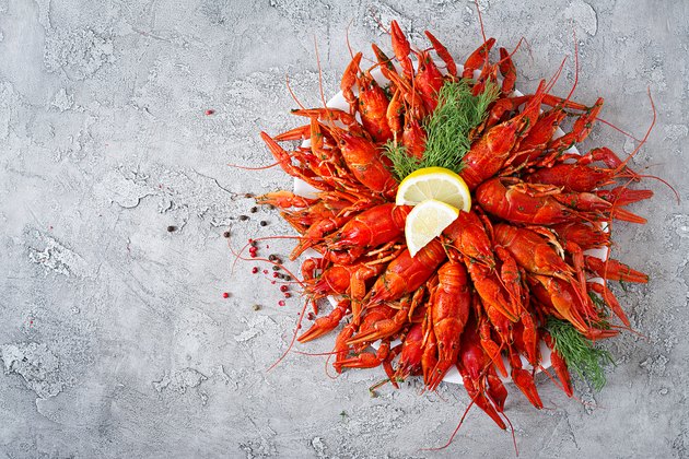 Crayfish. Red boiled crawfishes on table in rustic style, closeup. Lobster closeup. Border desig. Top view
