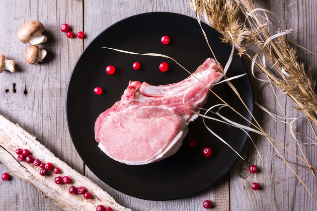 Fresh deer meat on black plate and wooden table