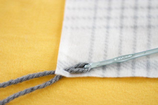 crochet hook pulling yarn through hole