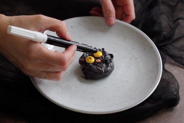 Drawing eyes on Reese's pieces with edible black marker