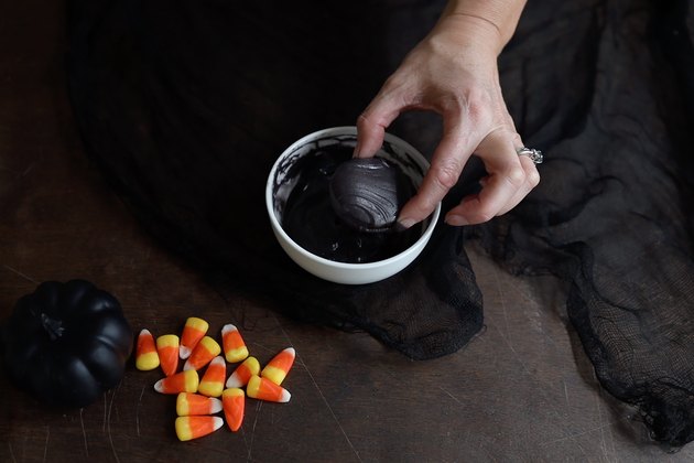 Dipping Oreo cookie in black candy melts