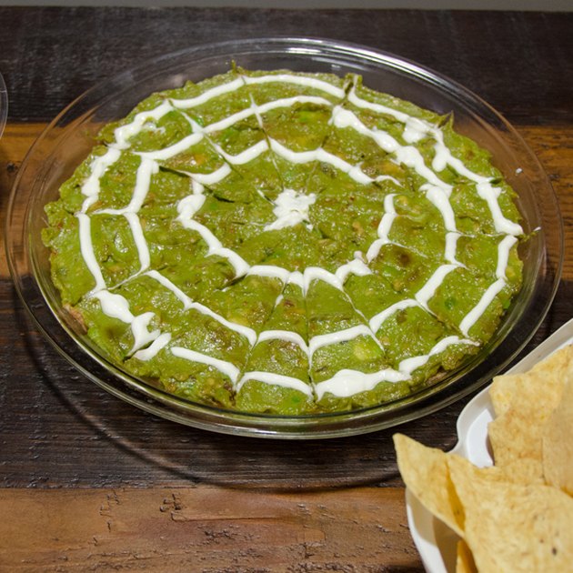 Guacomole topped with a sour cream spider web
