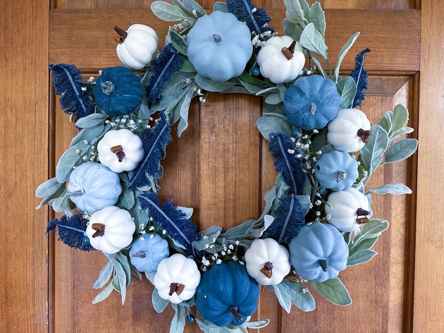 A Blue Pumpkin Wreath With Feathers Made From Old Jeans