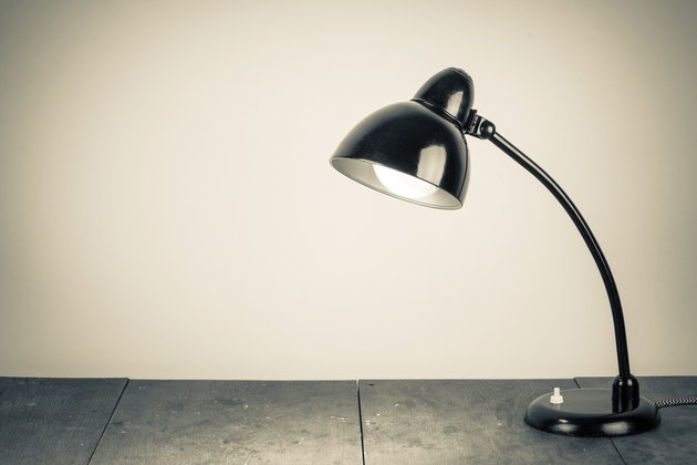 Vintage background with lighting retro desk lamp on wood table