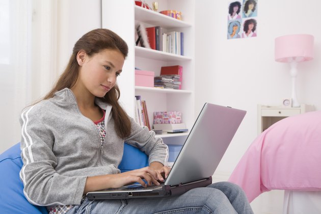 Teenage girl using laptop computer