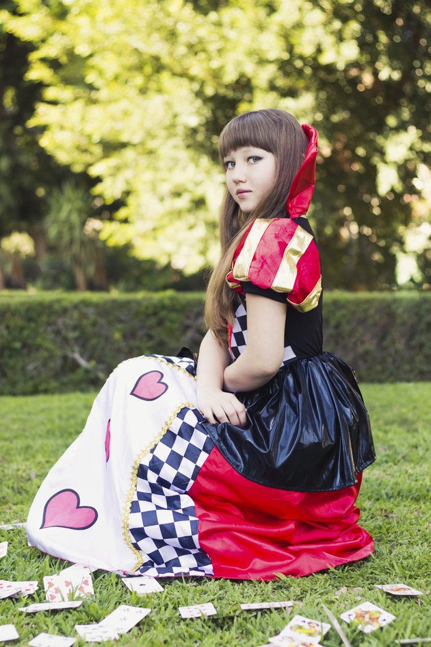 Cute young girl in a card's queen costume