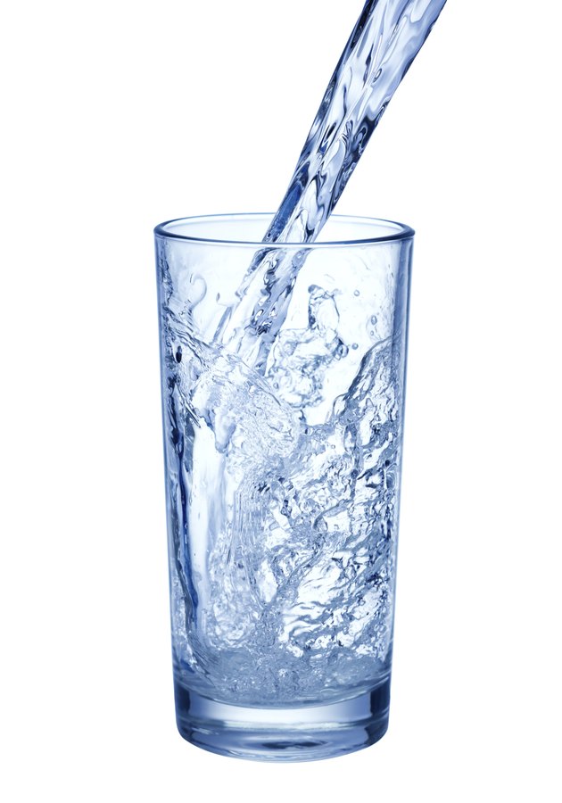 pouring water on glass on white background