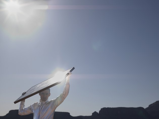 Young man with solar panel, portrait