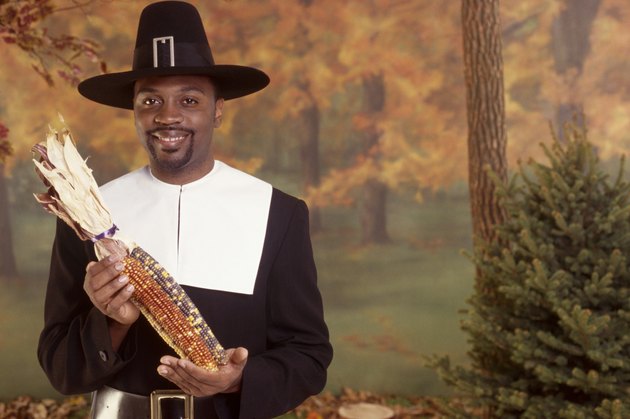 Man in pilgrim costume holding corn