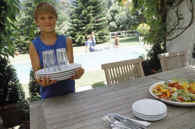 Boy carrying dishes to table