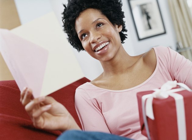 Surprised Woman Sitting Receiving a Card and Gift