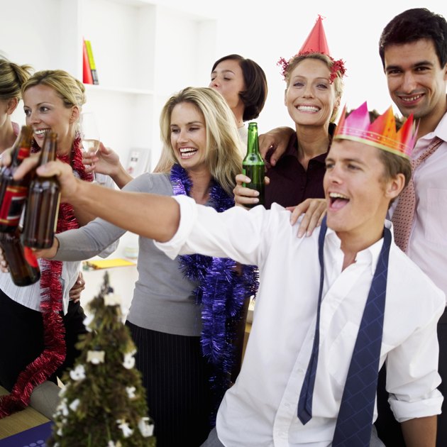 close-up of co-workers celebrating with beers at a office party