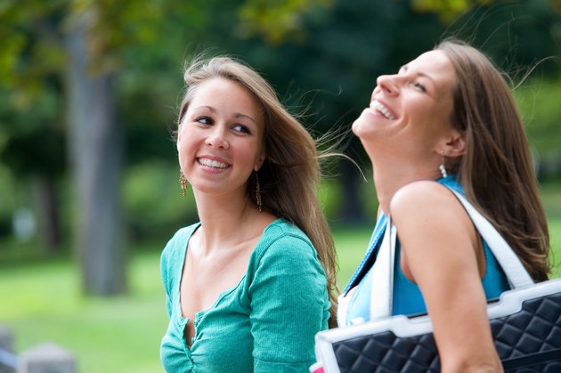 Two smiling teenage girls outdoors at park