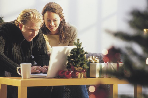 Couple using computer at Christmas