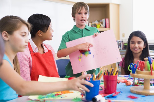 Elementary pupil discussing picture with classmates