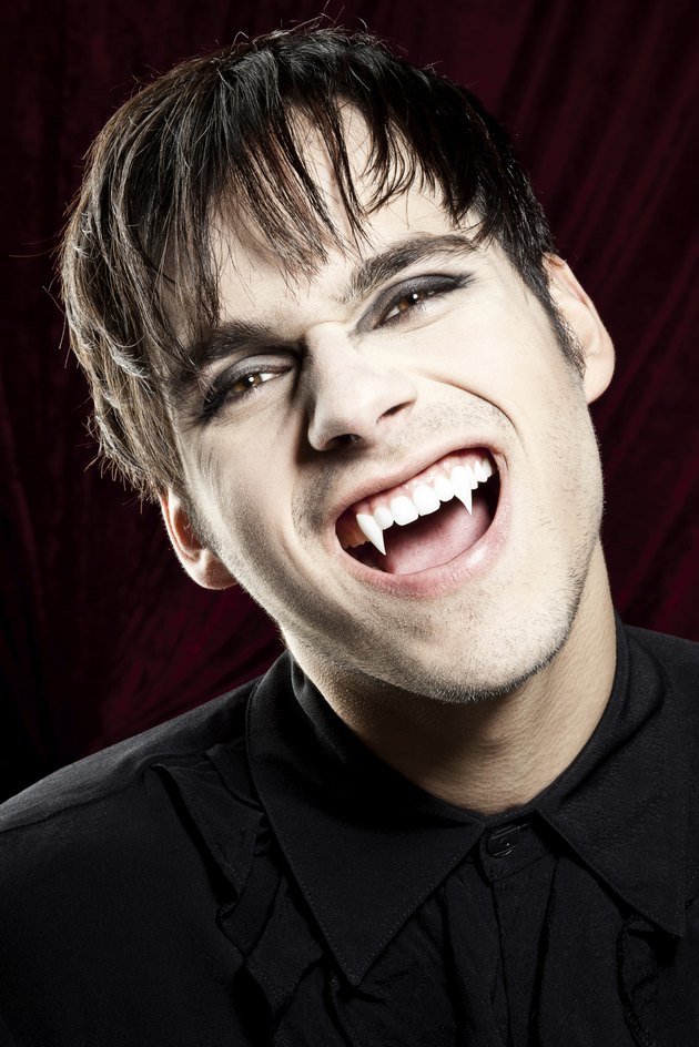 Male vampire laughing dangerously and showing his fangs