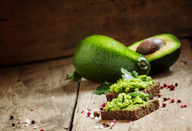 Sandwiches with black rye bread and avocado mousse with spices, selective focus