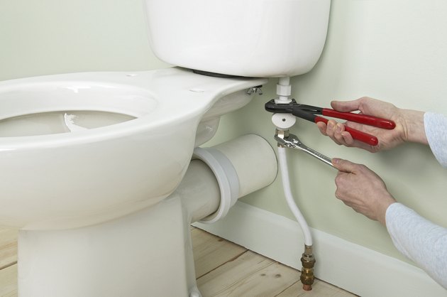 Using slip-joint pliers to brace inlet pipe
