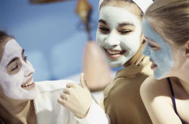 Three teenage girls wearing facial masks