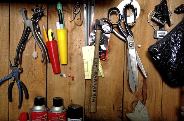 Tailor's tools hanging on wooden panel, close-up