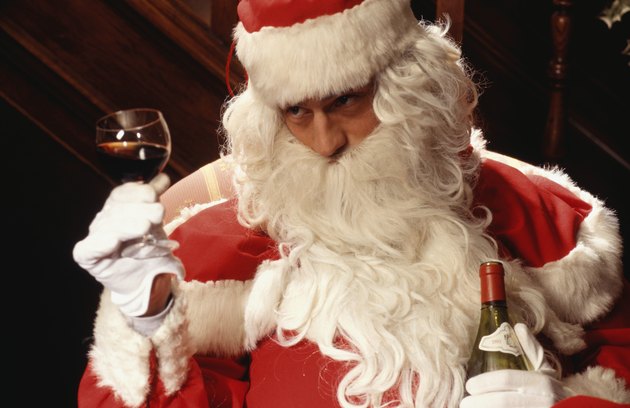 Santa Claus holding glass and bottle of wine