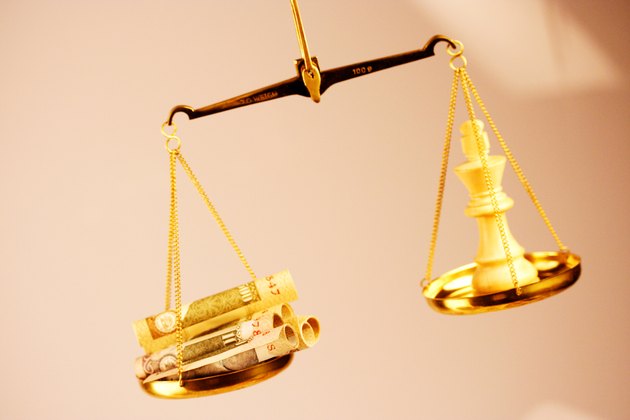 A balance of money and a chess piece