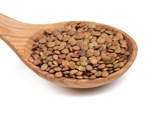 brown lentils in a wooden spoon