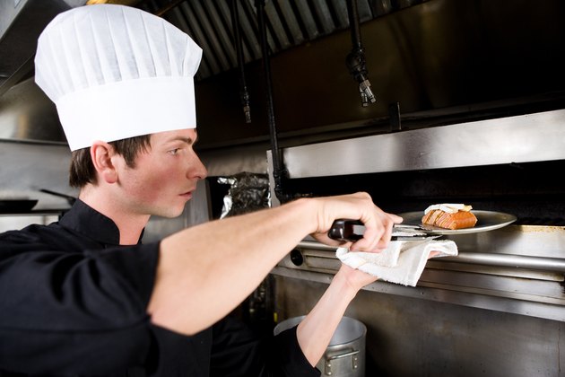 Chef pulling out baked salmon from oven