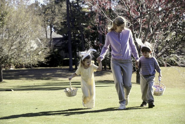 Mother walking on a lawn with her son and daughter