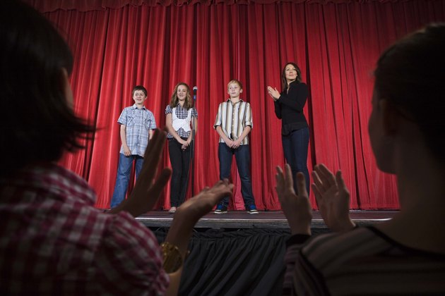 Audience clapping for students on stage