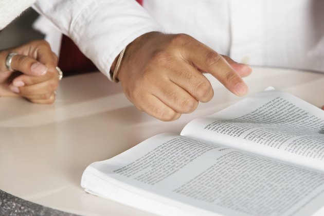 Mid section view of a man reading a book