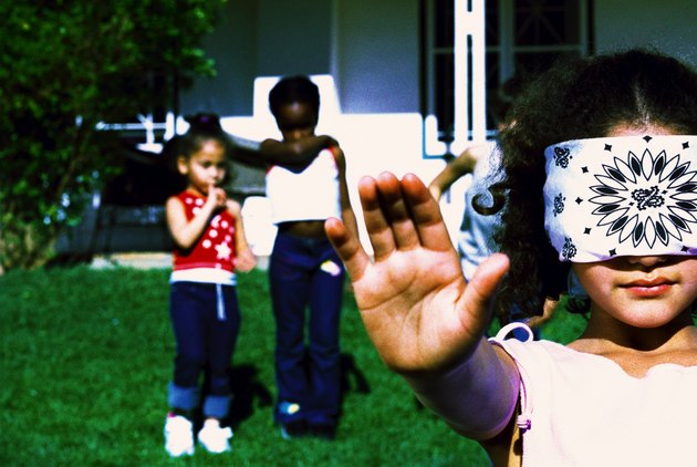 close-up of a girl (6-8) playing catch blindfolded
