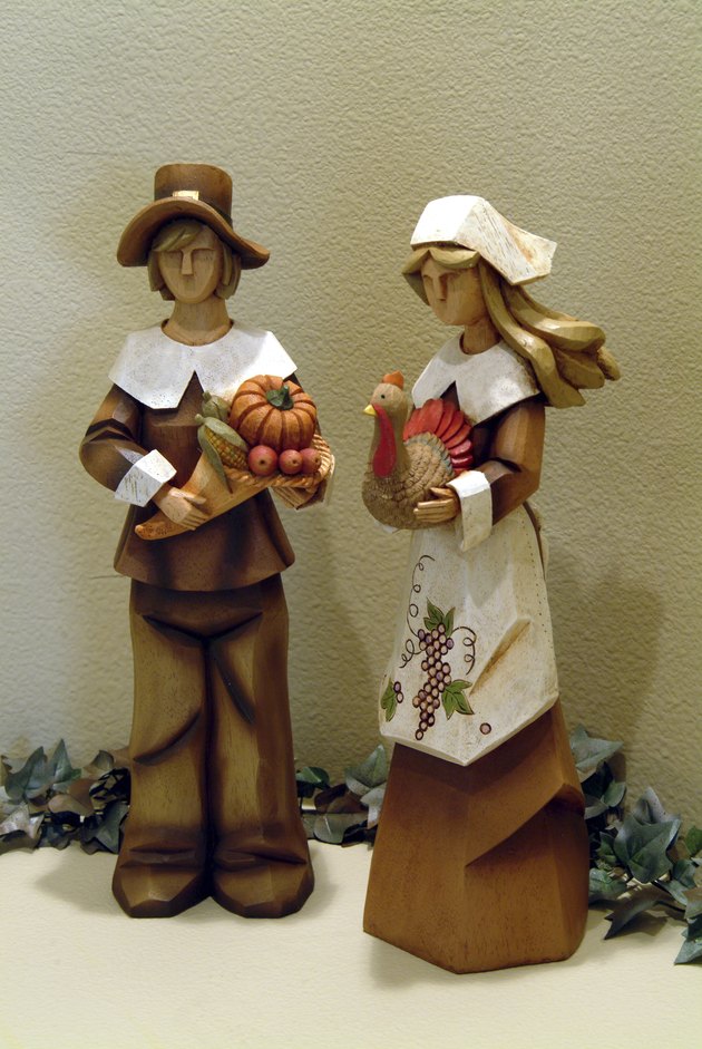 Two decorative wooden figurines of pilgrim couple