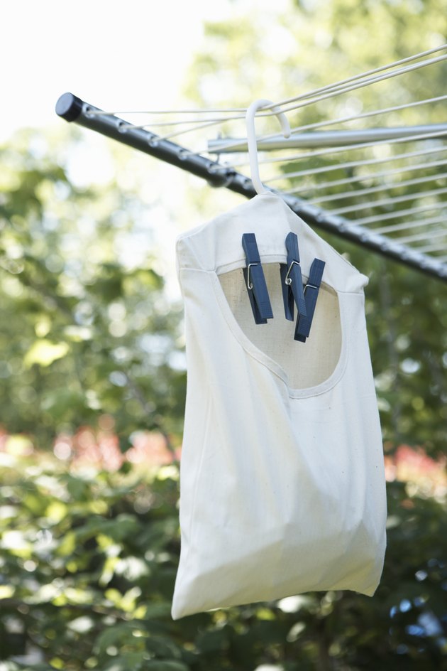 Bag of clothespins hanging from clothesline outdoors