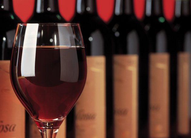 close-up of a glass of wine in front of an array of bottles