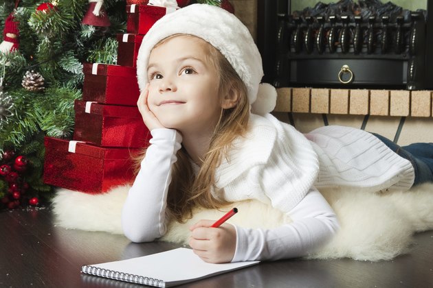 Pretty girl in Santa hat writes letter