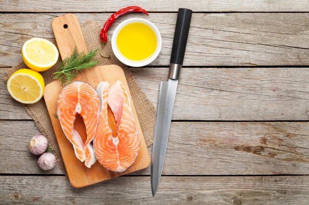Salmon, spices and condiments on wooden table. Top view with copy space