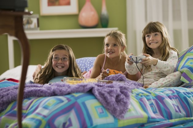 Girls playing video games at slumber party