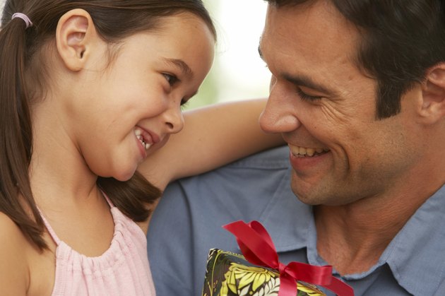 Girl (5-7) embracing father, close-up