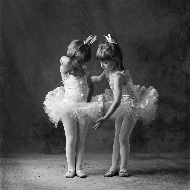 Two young caucasian ballerinas primp and get ready to dance