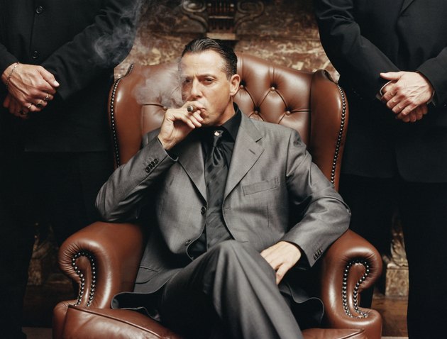 Wealthy Criminal Sitting in an Armchair Between two Bodyguards