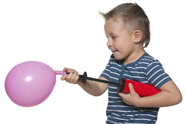 Little boy inflates a balloon