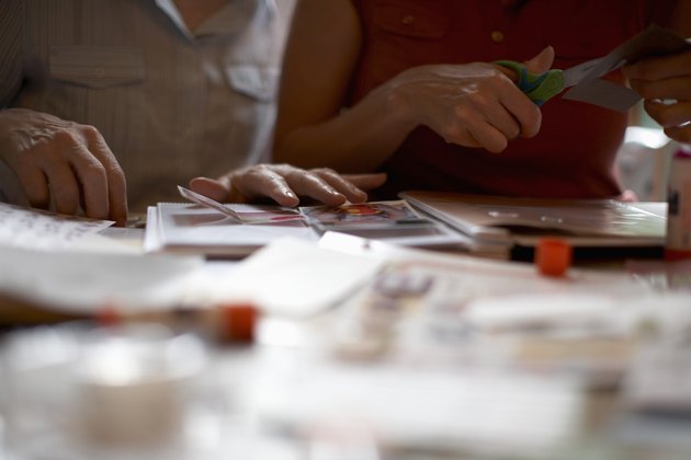 Two women assembling scrapbook, mid section