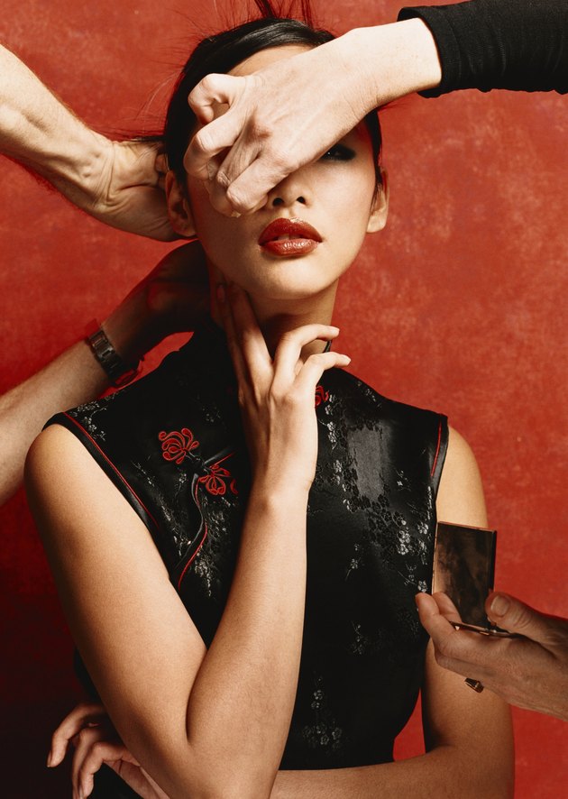 Make Up Artist Applying Make Up and Hairdresser Adjusting The Hair of a Female Model