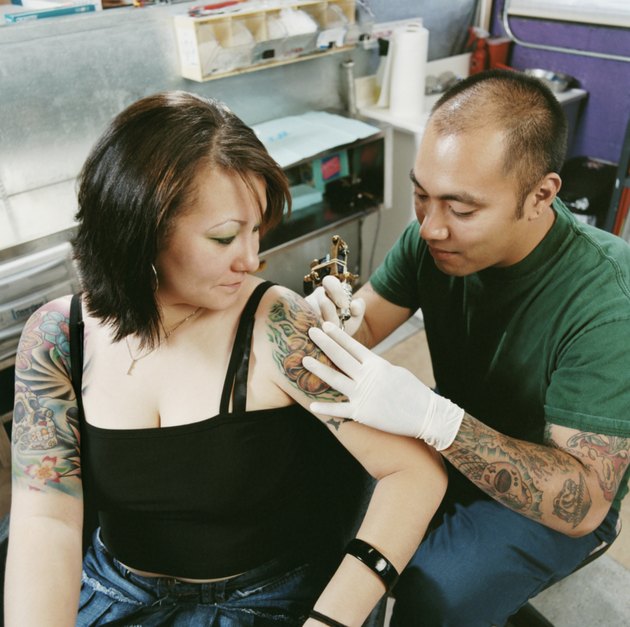 Tattooist Tattooing a Woman's Arm