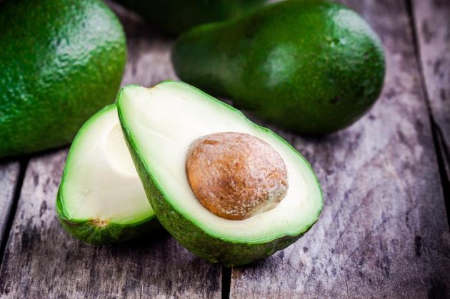 fresh raw avocado on a rustic wooden table