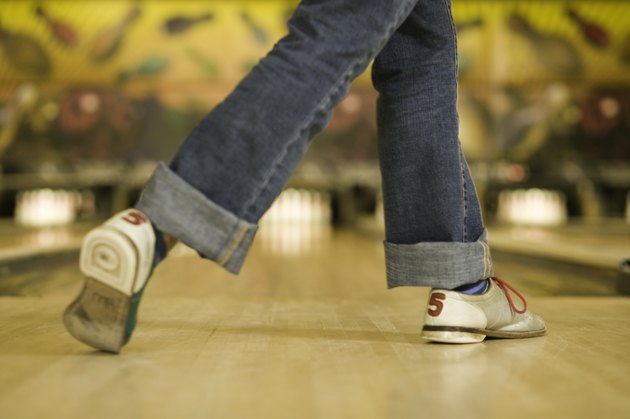 Woman getting ready to bowl ball, low section
